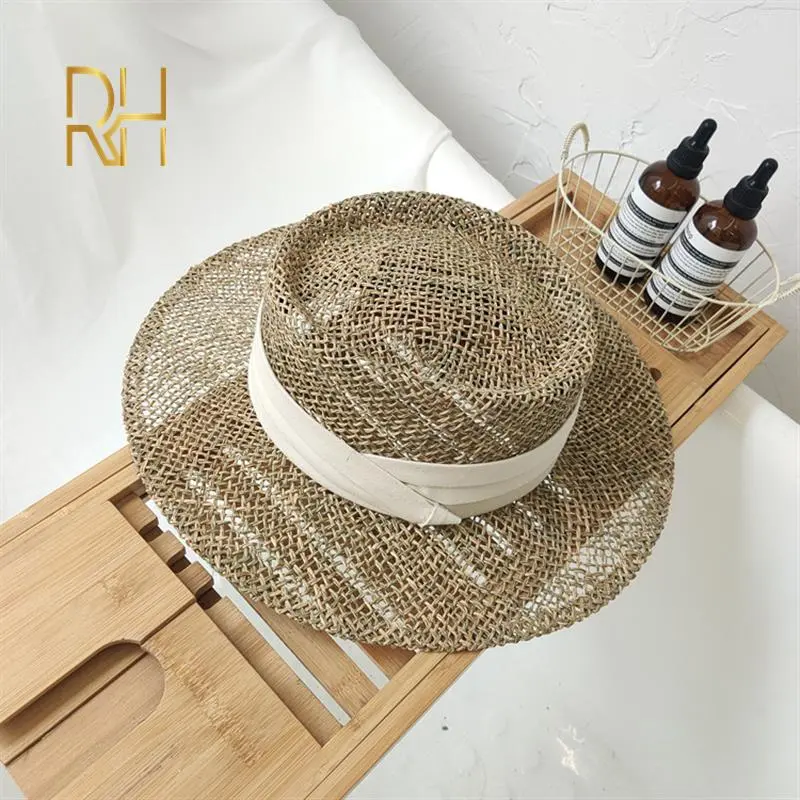 Travel Natural seagrass hollow flat brim hat ladies summer porkpie concave round sun hat beach straw hat with ribbon wholesale